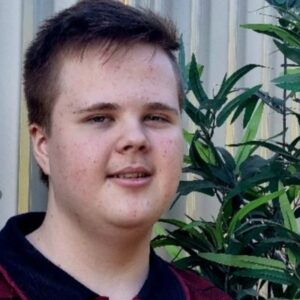 headshot of young person grinning at camera.