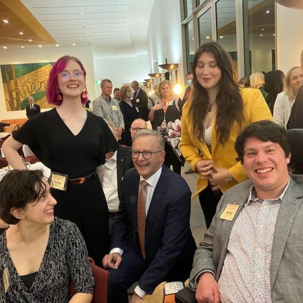 CYDA board members with Prime Minister Anthony Albanese at the NDIS Jobs and Skills Forum 2022. Prime Minister Anthony Albanese is sat with a board member standing either side of him, and two other people looking towards the group and the camera.