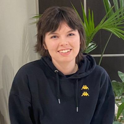 Young person with short dark hair, smiling directly into the camera.