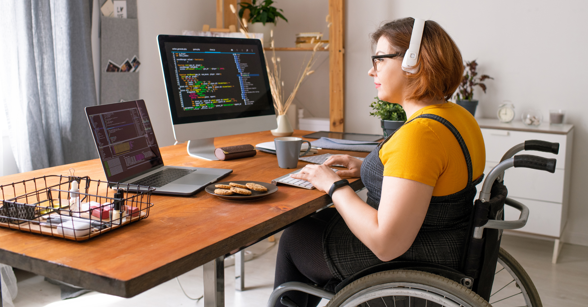 Woman who uses a wheelchair is working at her desk coding.