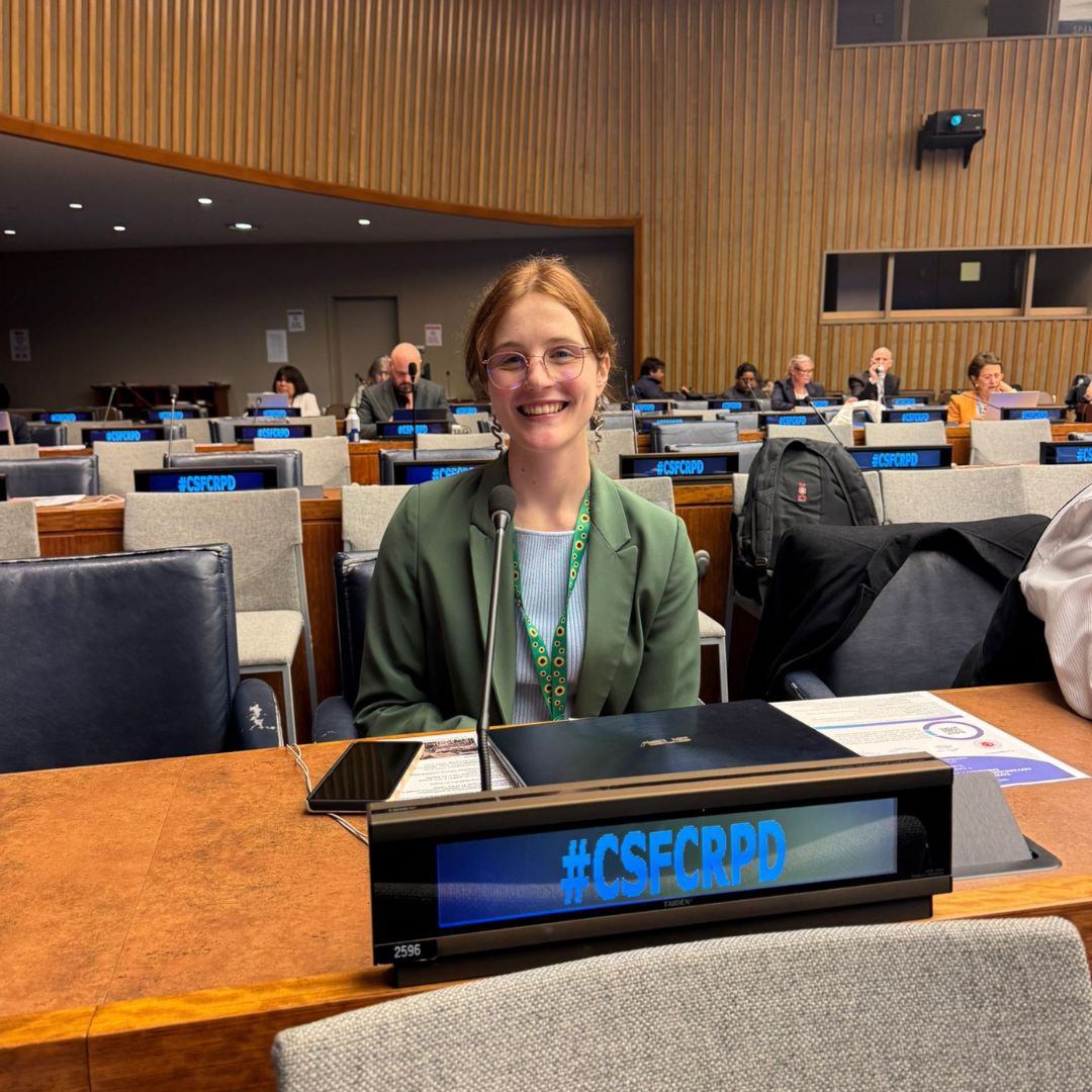Ebe sitting smiling after delivering an intervention at the civil society forum